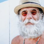 Cheerful mature man with gray hair smiling and enjoying sunny day