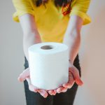 Woman in yellow t-shirt holding white tissue paper