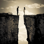 Man and woman standing on opposite side of a cliff