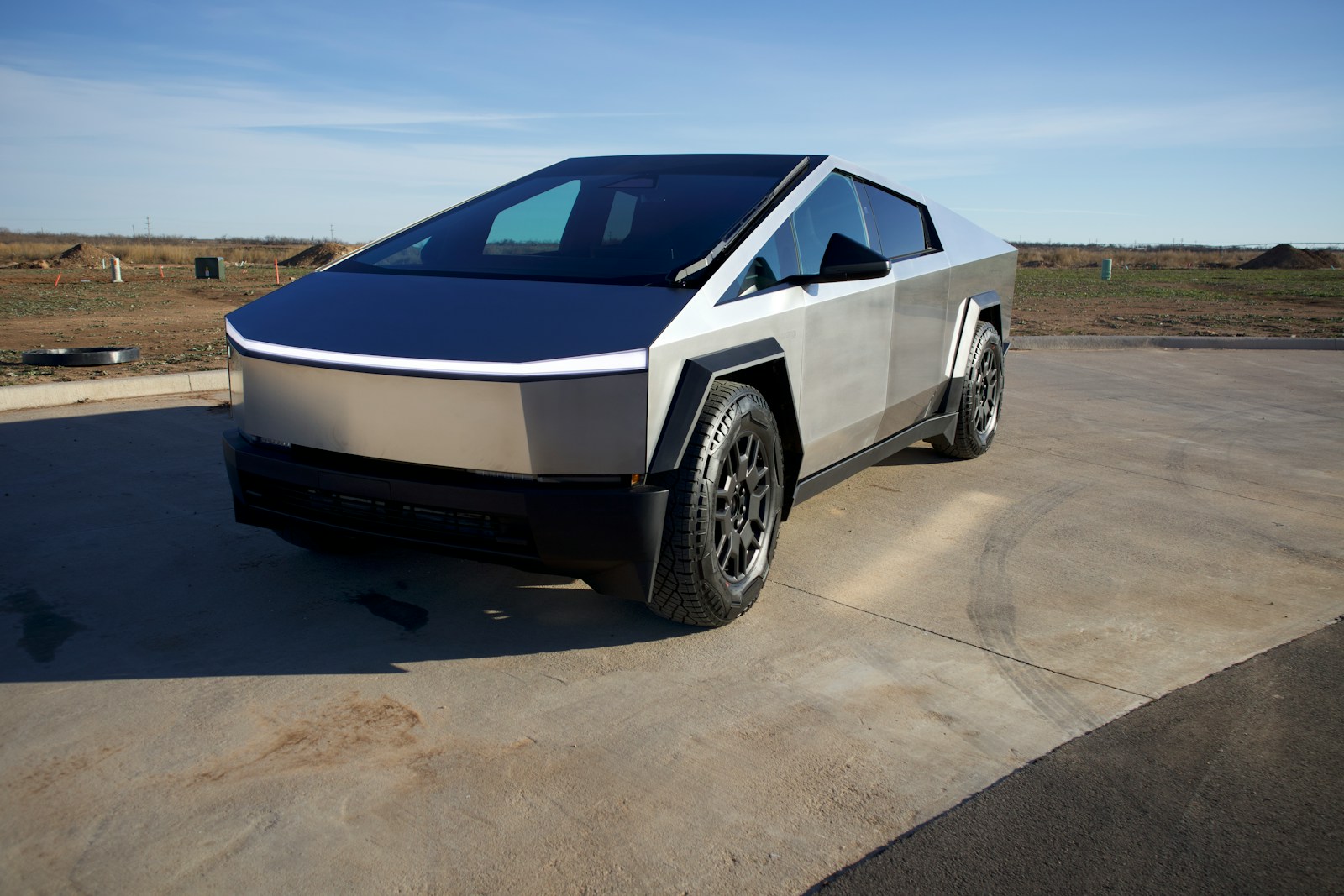 A silver and black Tesla Cybertruck parked in a parking lot